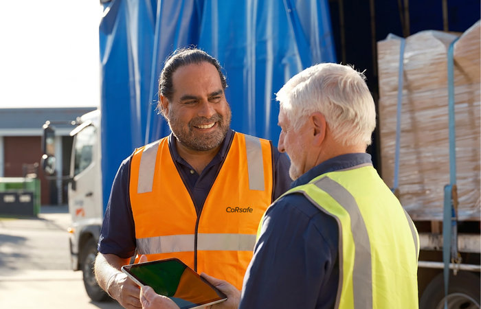 a man in safety vests talking to another man